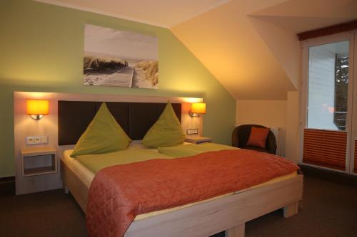 a bedroom with a bed with green and orange sheets at Hus op de Diek in Sankt Peter-Ording
