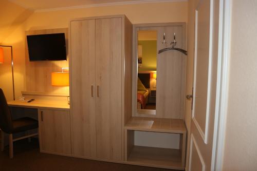 a room with a desk and a cabinet with a mirror at Hus op de Diek in Sankt Peter-Ording