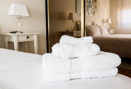 ログローニョにある4Uのホテルのベッドの上にタオルを積み重ねる