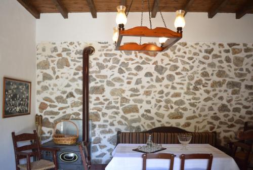 a dining room with a table and a stone wall at Epavlis Iosif in Khóra Sfakíon