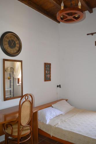 a bedroom with a bed and a clock and a chair at Epavlis Iosif in Khóra Sfakíon