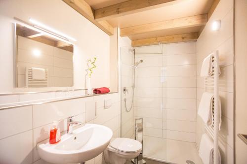 a white bathroom with a sink and a toilet at Weingut Blank in Homburg