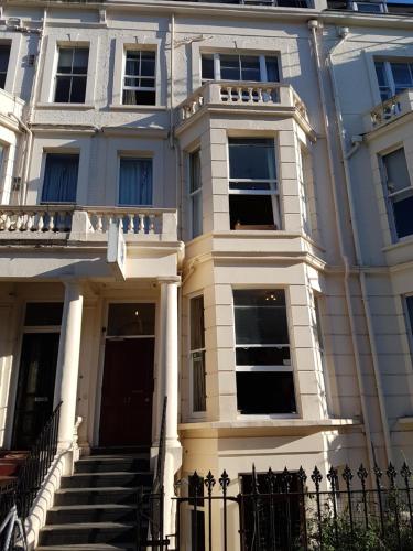 a large white building with a staircase in front of it at Barmy Badger Backpackers in London
