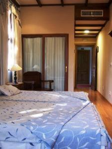 a large bed in a bedroom with a large blue blanket at Balneario San Andres in Canena
