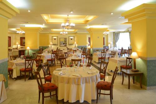 ein Restaurant mit Tischen und Stühlen in einem Raum in der Unterkunft Hotel Central in Ploieşti