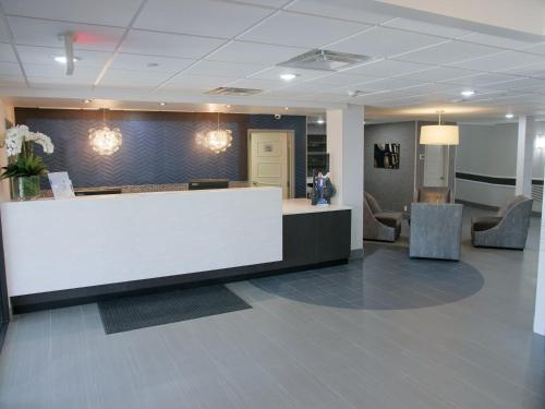 an office lobby with a reception desk and chairs at Wingate by Wyndham Louisville Airport Expo Center in Louisville