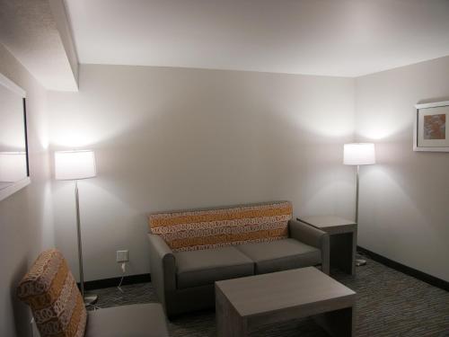 a waiting room with a couch and two lamps at Wingate by Wyndham Louisville Airport Expo Center in Louisville
