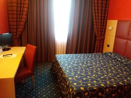a hotel room with a bed and a desk with a computer at Hotel Panorama in Cambiano
