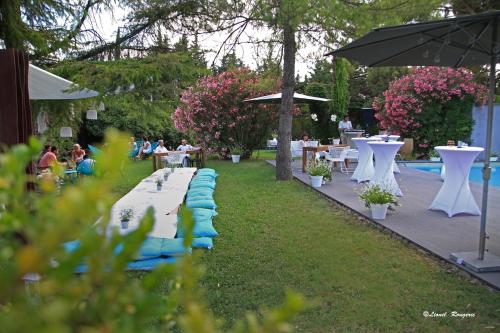 a garden with tables and chairs and people sitting at tables at Le Safari Hotel Restaurant in Carpentras