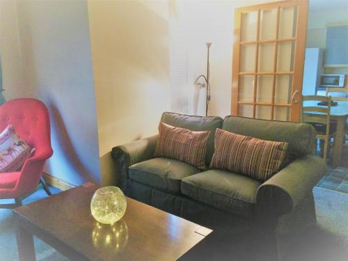 a living room with a couch and a table at Dunroamin Self-Catering Apartment in Aviemore