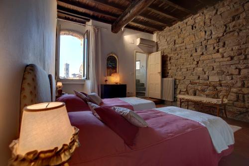フィレンツェにあるTorre Donatiのレンガの壁、ベッド2台が備わるベッドルーム1室が備わります。