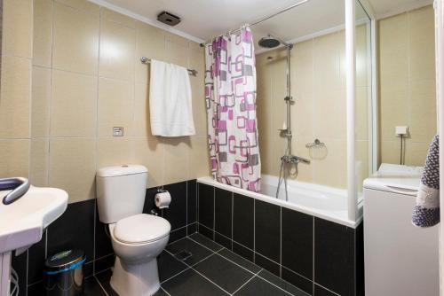 a bathroom with a toilet and a tub and a sink at Paleochora Apartments in Palaiochóra