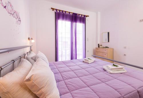 duże różowe łóżko w pokoju z oknem w obiekcie Paleochora Apartments w mieście Palaiochóra