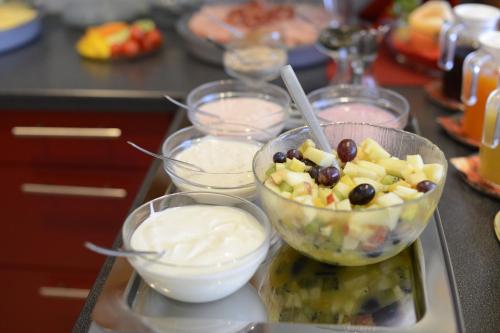 a tray of food with a bowl of fruit and yogurt at Haus Alpina in Häselgehr