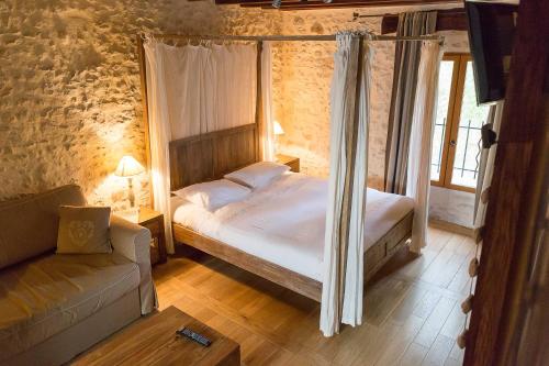 a bedroom with a canopy bed and a couch at La Ferme de Vintué in Étréchy