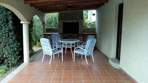 un patio con mesa, sillas y chimenea en Villa Camila en Villa Giardino