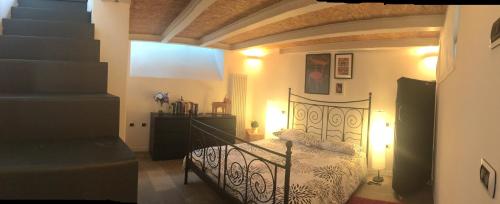 アオスタにあるMaison Grivon Chalet nel Borgo di Charvensodのベッドルーム1室(黒いベッド1台、階段付)