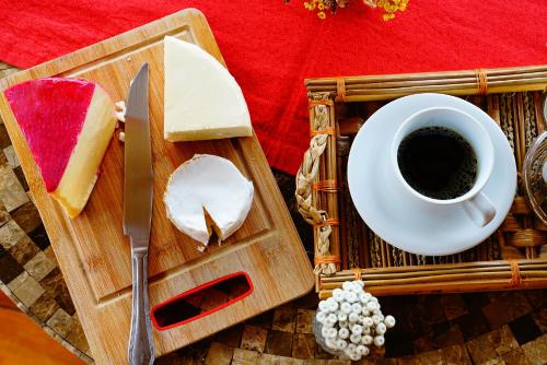 a cutting board with a cup of coffee and a piece of bread at Pousada Meu Talento in Alto Paraíso de Goiás