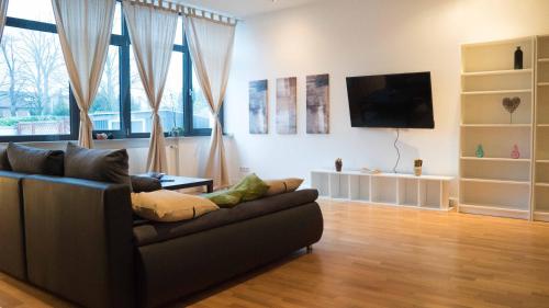 a living room with a couch and a flat screen tv at Work & stay Langenfeld in Langenfeld