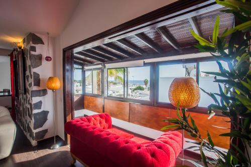 a red couch in a room with a large window at Palm Villa in Puerto del Carmen