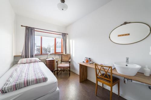 a bedroom with a bed and a sink and a mirror at Eric the Red Guesthouse in Reykjavík