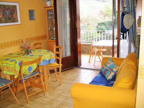 sala de estar con mesa y sofá amarillo en 2VAD13 Studio proche centre-ville, en Collioure