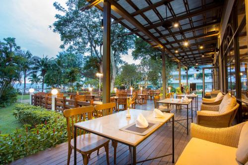 an outdoor restaurant with tables and chairs and tablesktop at Novotel Rayong Rim Pae Resort in Klaeng