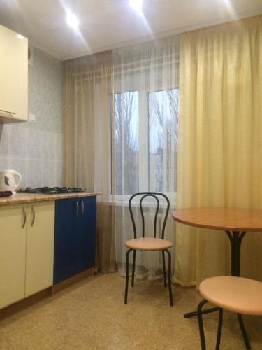 a kitchen with two chairs and a table and a window at проспект металлургов 9 in Kryvyi Rih