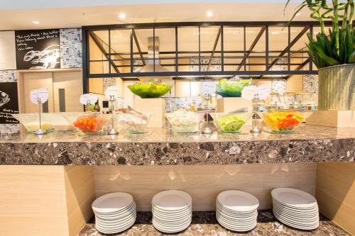 a restaurant with a counter with plates and bowls of food at Novotel Rayong Rim Pae Resort in Klaeng