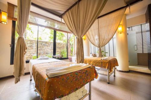 a bedroom with two beds and a large window at Novotel Rayong Rim Pae Resort in Klaeng