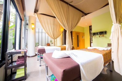 a bedroom with two beds and a room with windows at Novotel Rayong Rim Pae Resort in Klaeng