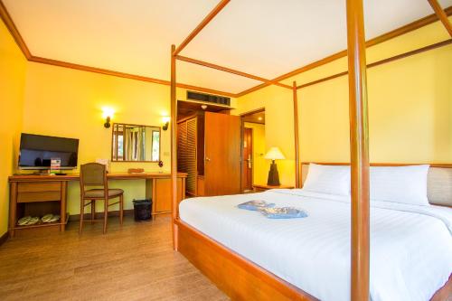 a bedroom with a bed and a desk with a computer at Novotel Rayong Rim Pae Resort in Klaeng