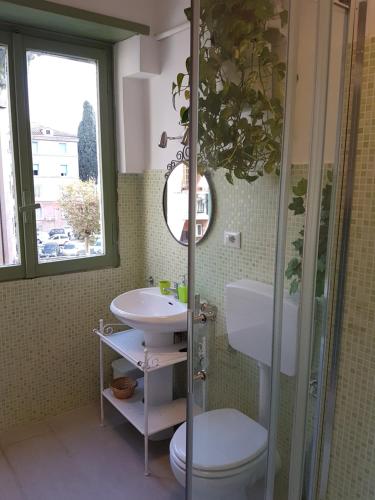 un bagno con lavandino, WC e specchio di Le Tre Sorelle B&b Garbatella a Roma