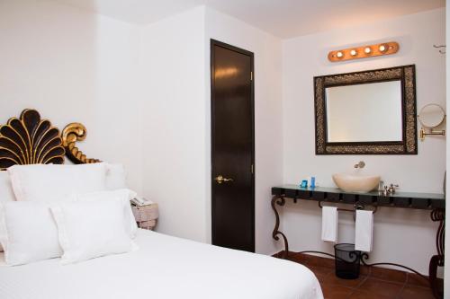a bedroom with a white bed and a sink at Hotel Herencia By Hosting House in Morelia