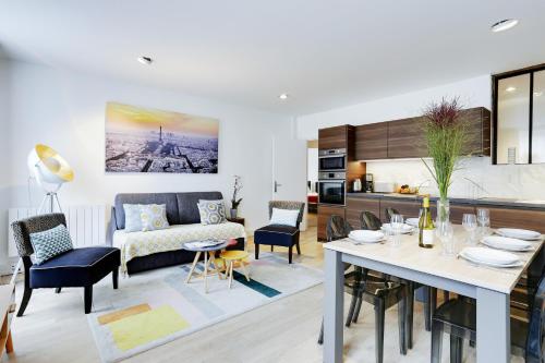 une cuisine et un salon avec une table et des chaises dans l'établissement Apartments Paris Centre - At Home Hotel, à Paris