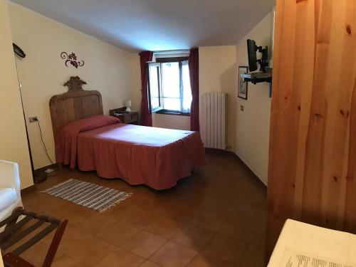a bedroom with a bed and a window in a room at Hotel Ristorante Combolo in Teglio