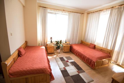 une chambre avec deux lits et une grande fenêtre dans l'établissement Complex Apolon, à Nessebar
