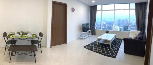 a living room with a table and a room with a view at VORTEX SUITES KLCC by PNUT With NETFLIX in Kuala Lumpur