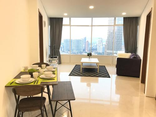a living room with a table and chairs and a large window at VORTEX SUITES KLCC by PNUT With NETFLIX in Kuala Lumpur