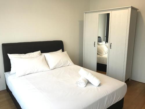 a bedroom with a white bed and a mirror at VORTEX SUITES KLCC by PNUT With NETFLIX in Kuala Lumpur