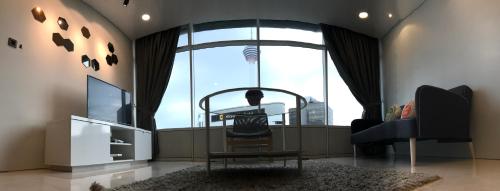 a living room with a large window with a chair and a table at VORTEX SUITES KLCC by PNUT With NETFLIX in Kuala Lumpur