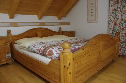 a wooden bed in a bedroom with a wooden floor at Marga`s Ferienwohnung in Lembach im Mühlkreis