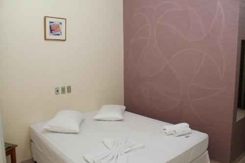 Una habitación con una cama con dos toallas encima. en Emburi Hotel, en Piratininga