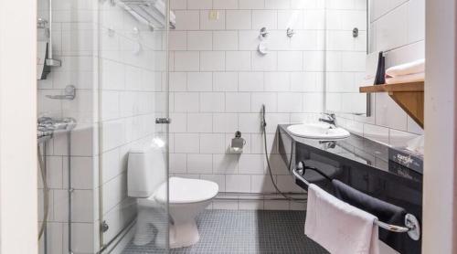 La salle de bains blanche est pourvue de toilettes et d'un lavabo. dans l'établissement Original Sokos Hotel Rikala Salo, à Salo