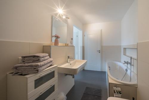 a white bathroom with a sink and a mirror at Design Apartments - "Am Schlosspark" Adults Only in Potsdam