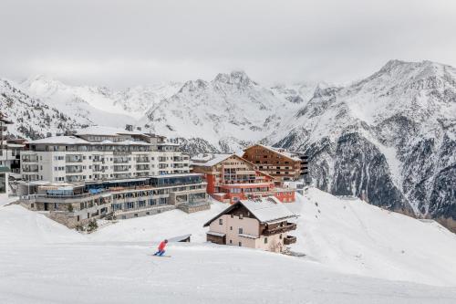 a person is skiing down a snow covered mountain at Hotel Enzian Hochsölden Superior in Sölden