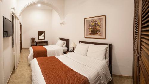 a bedroom with two beds in a room at Hotel La Plazuela in Popayan