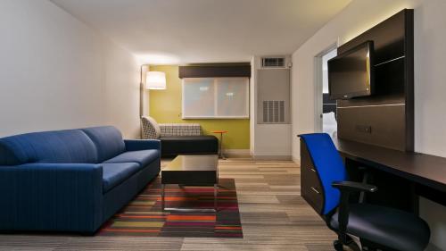 a living room with a blue couch and a tv at Holiday Inn Express Hotel & Suites Everett by IHG in Everett