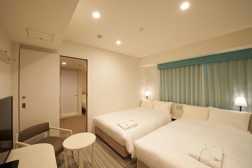 سرير أو أسرّة في غرفة في Sotetsu Fresa Inn Ginza Sanchome