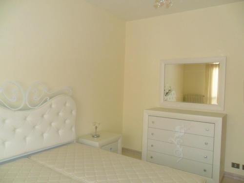 1 dormitorio con cama, tocador y espejo en Appartamento Sacro Cuore, en Módica